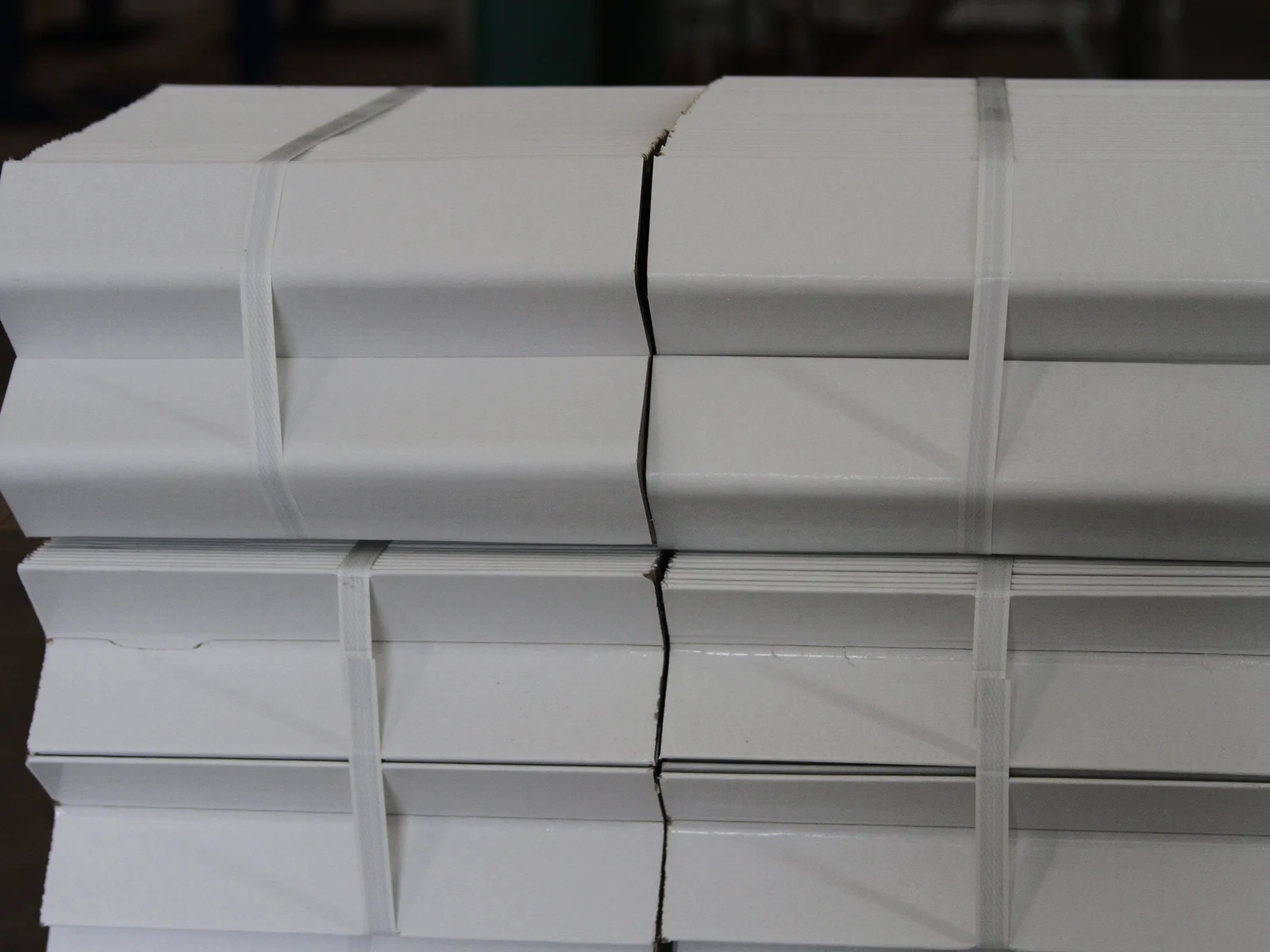 Atados de esquineros de cartón blancos flejados y listos para la entrega